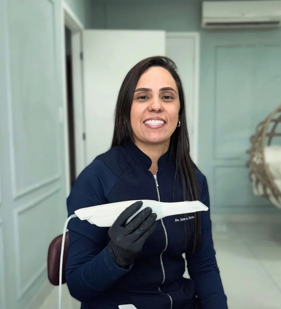 Dra. Jacmara Neves segurando o scanner intraoral 3Shape no consultório